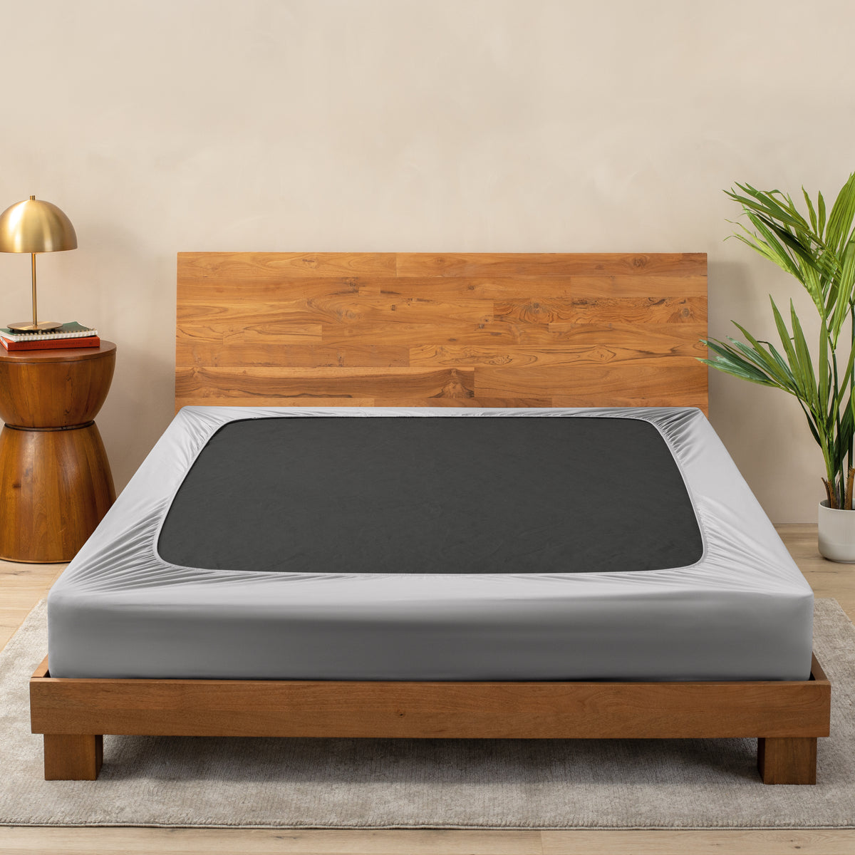 A cover on a box spring set on a wooden bed frame