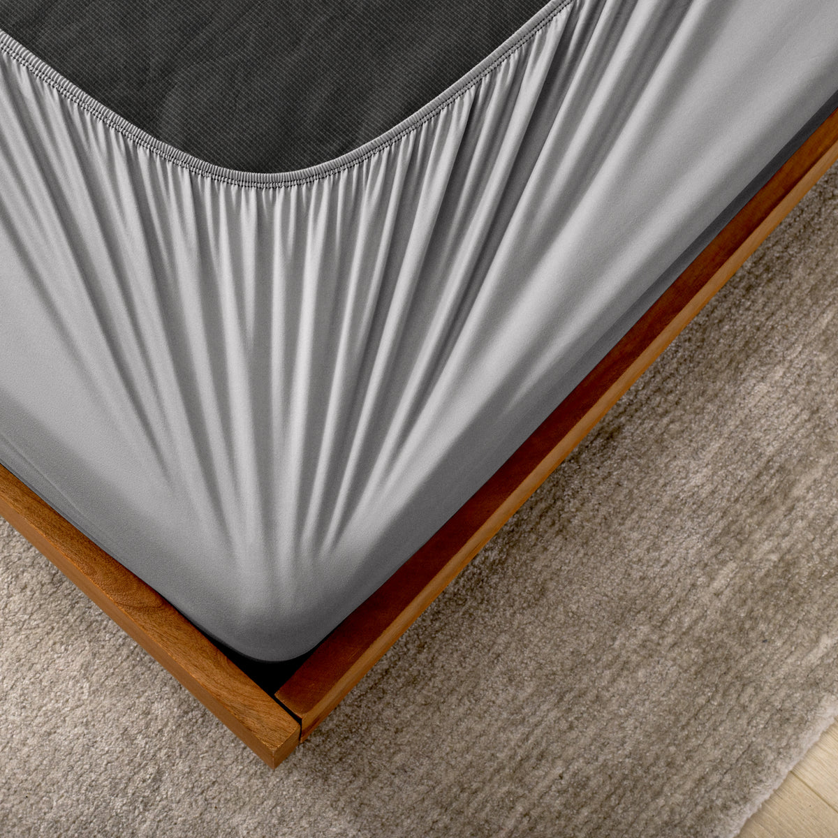 The corner of a box spring with a cover on it