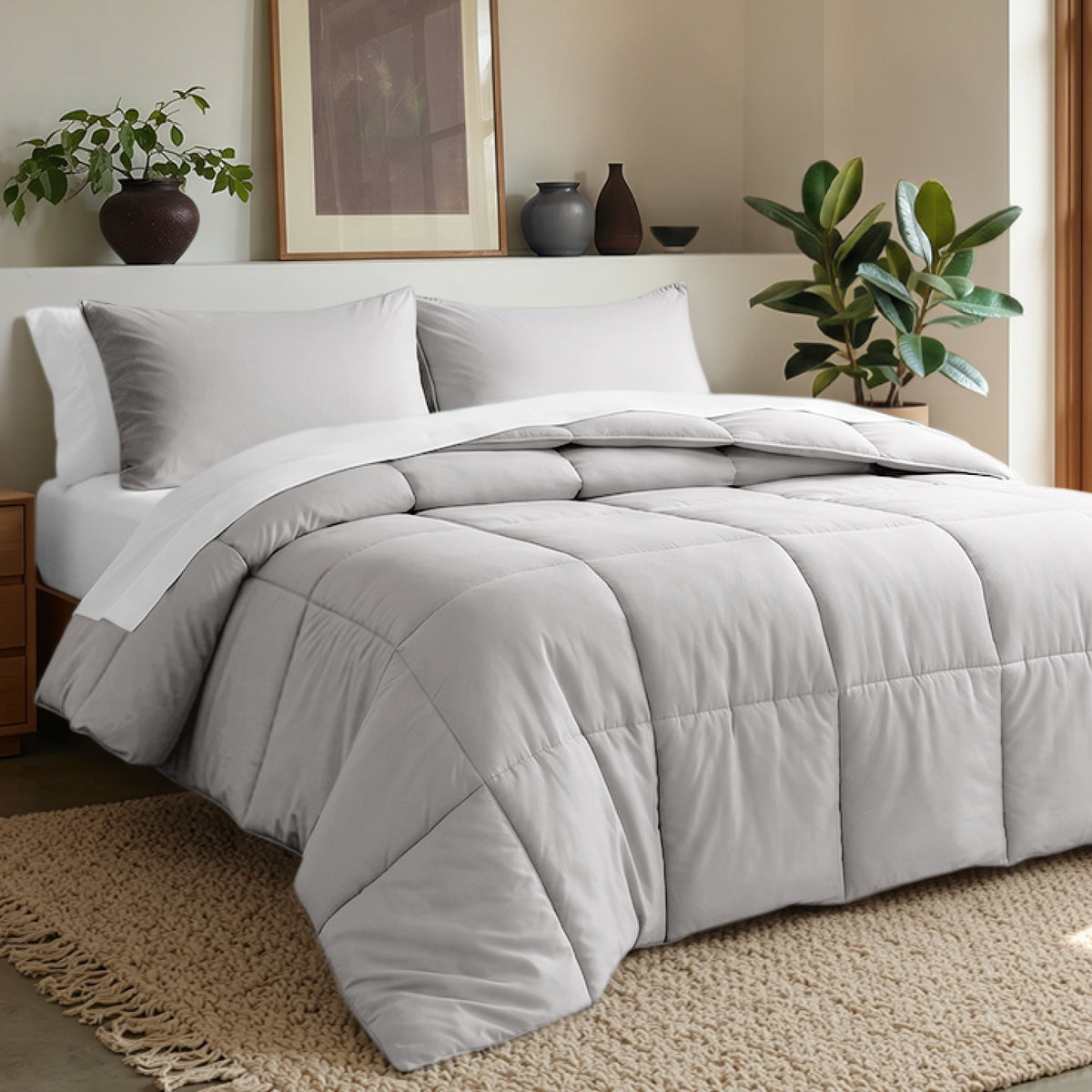 Comforter set on a bed in a bedroom with plants and decor.