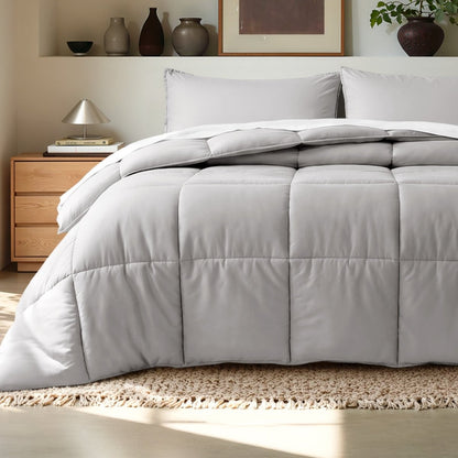 Comforter on a bed in a bedroom setting with a wooden nightstand and decorative items.