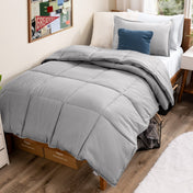 Bed with comforter and pillows in a dorm room