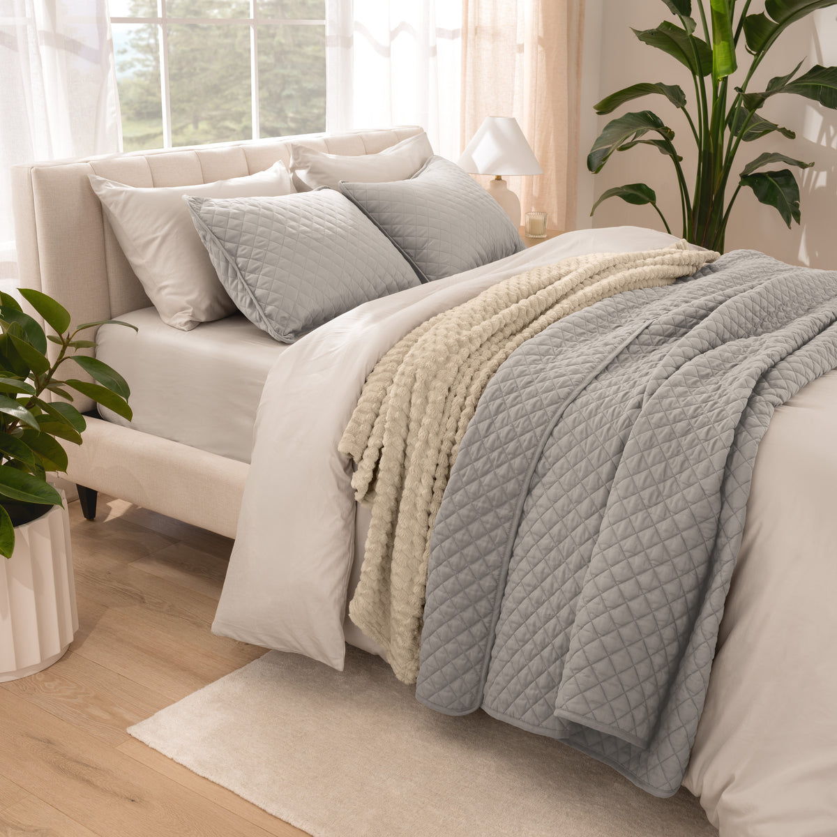 Side view of bed with coverlet set draped on a bed made with a duvet set