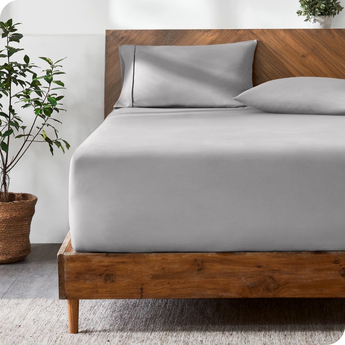 Wooden bed with ultra soft bedding in a minimalistic room.