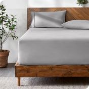 Wooden bed with ultra soft bedding in a minimalistic room.