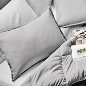Microfiber pillow sham set on a bed with a magazine on top of the comforter.