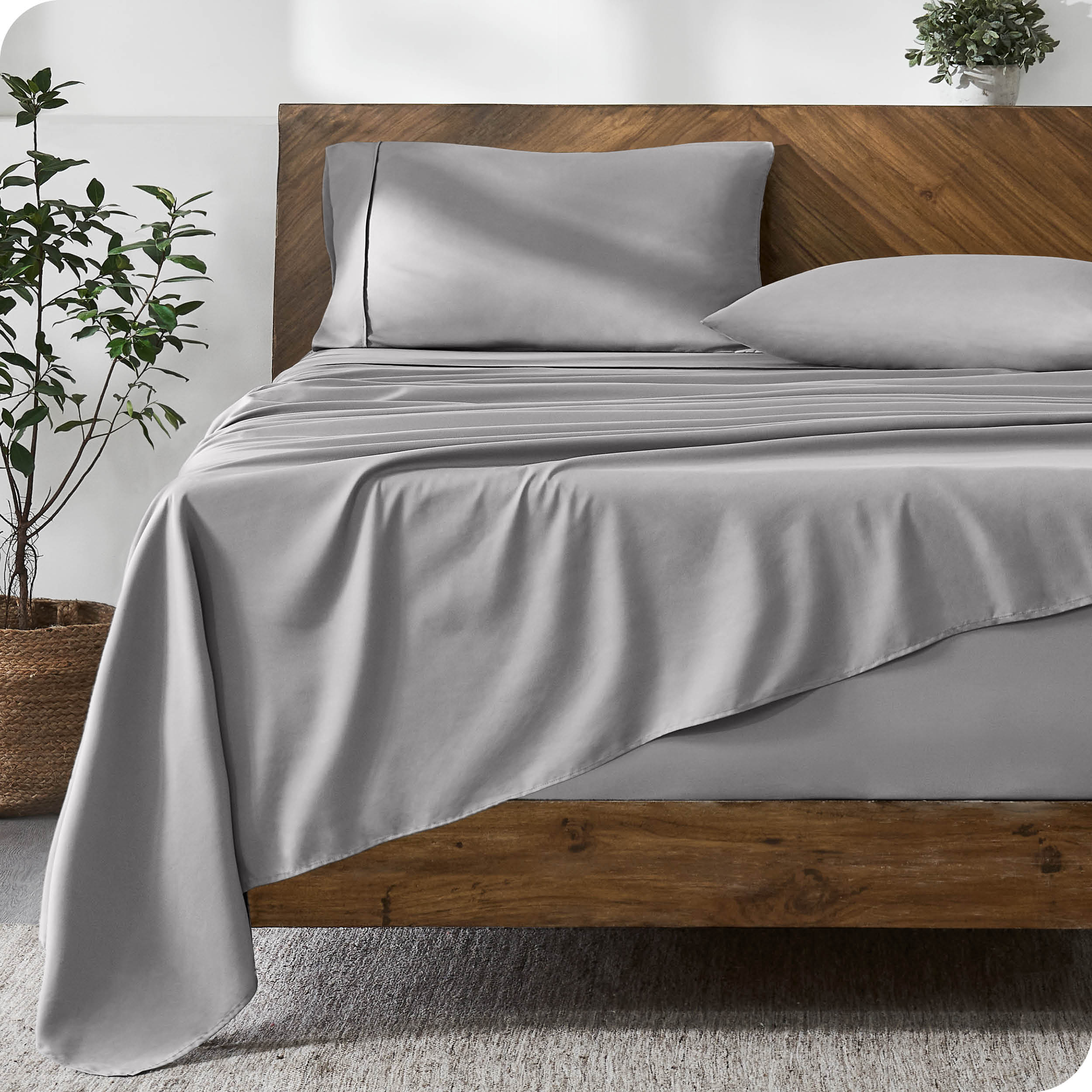A modern bed with a microfiber sheet set on the mattress.