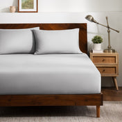 A bed dressed in a fitted sheet and two matching pillowcases.