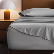 Microfiber bed sheets on a neatly made bed with a wooden headboard and nightstand.