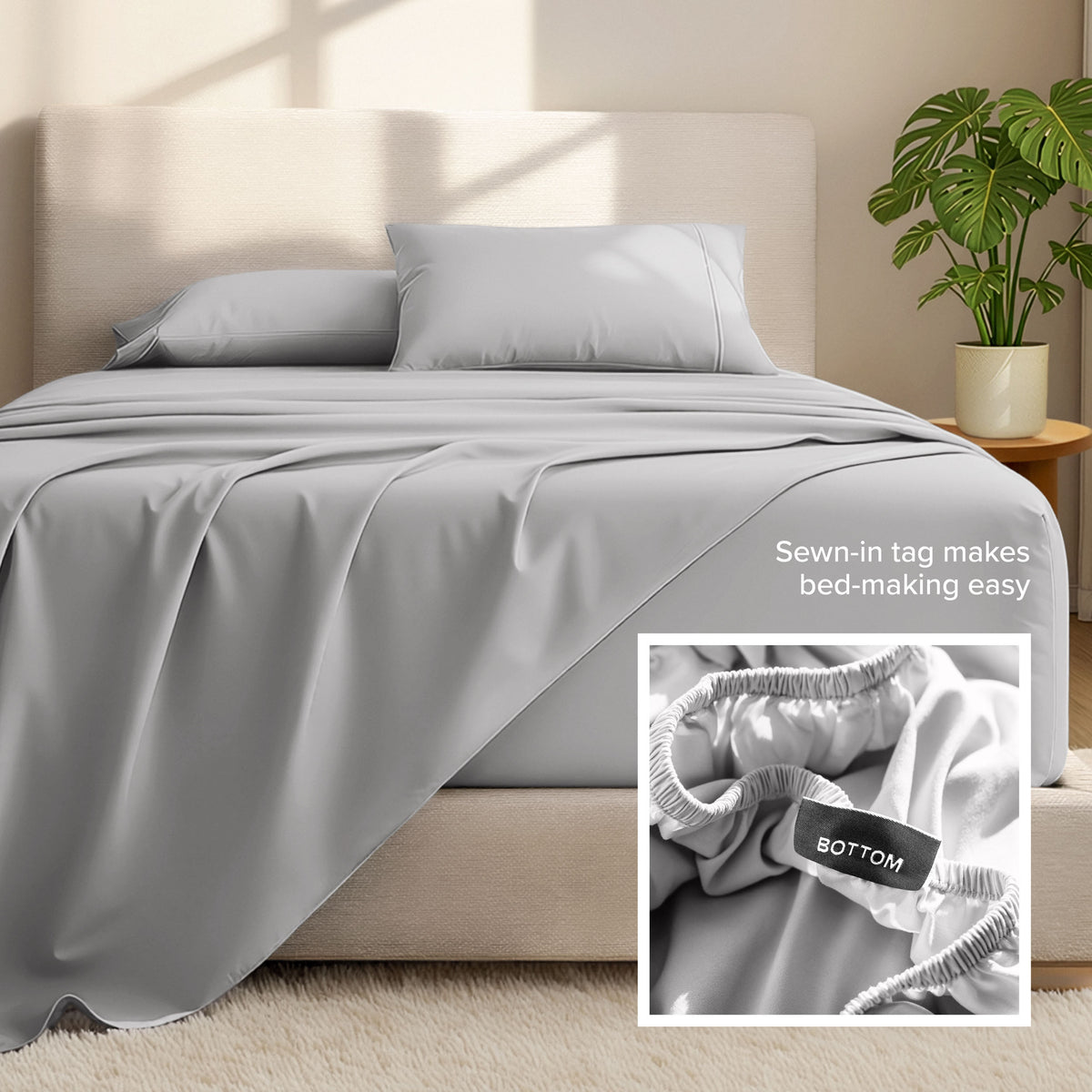 Bed sheets and pillows on a bed with a plant in the background