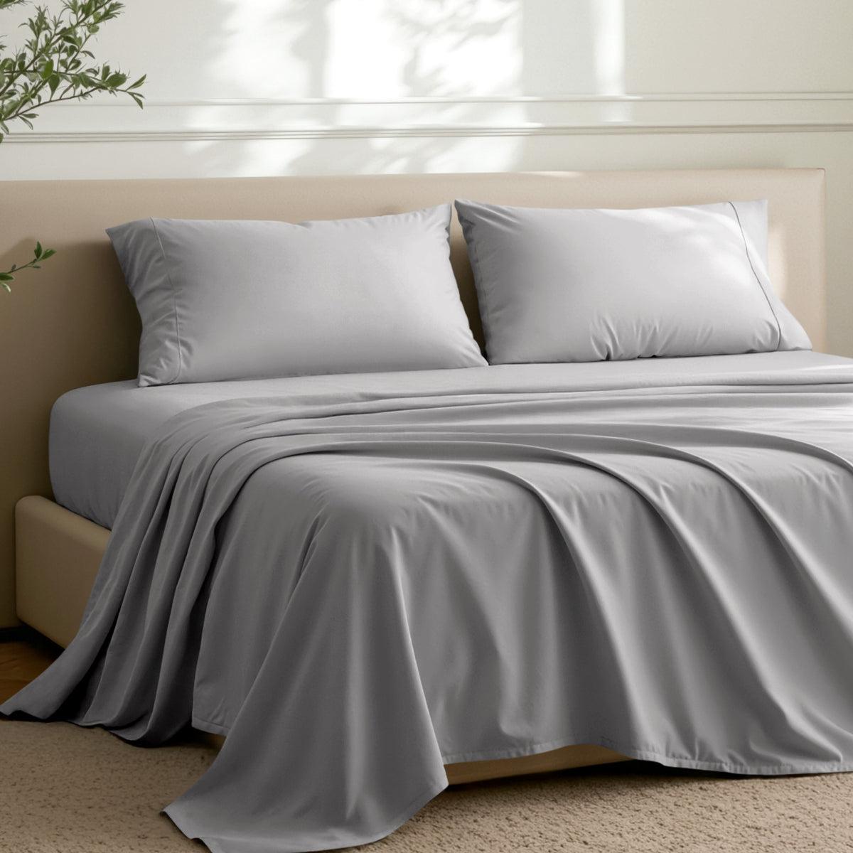 Microfiber sheets on a bed in a well-lit room with a plant.