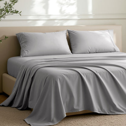 Microfiber sheets on a bed in a well-lit room with a plant.