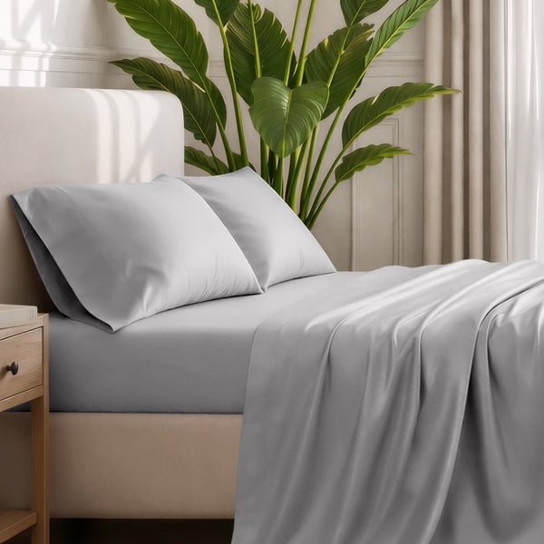 Ultra-soft sheets and pillowcases on a bed with a plant in the background