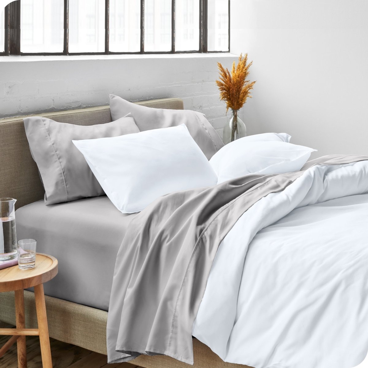 A side view of a bed made with microfiber sheets and a white duvet cover