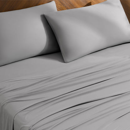 Bed sheets and pillowcases on a bed with a wooden headboard