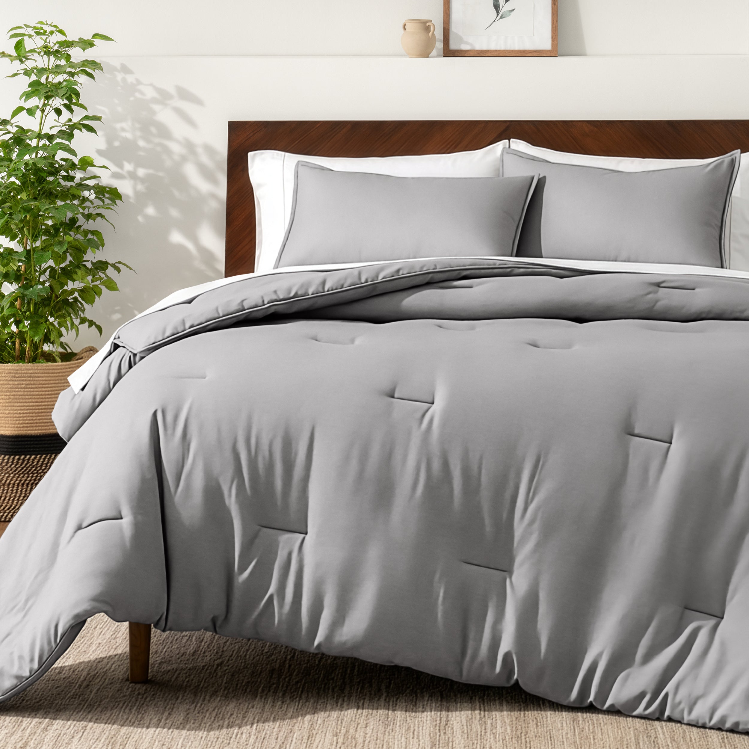 Bedding set on a bed in a bedroom with a side table and lamp.