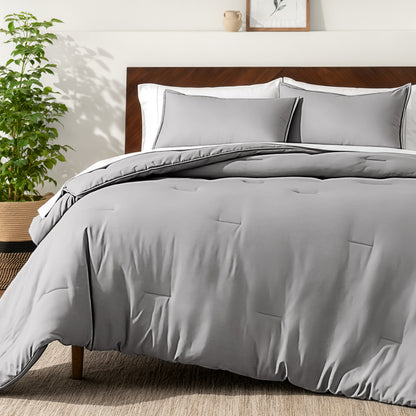 Bedding set on a bed in a bedroom with a side table and lamp.