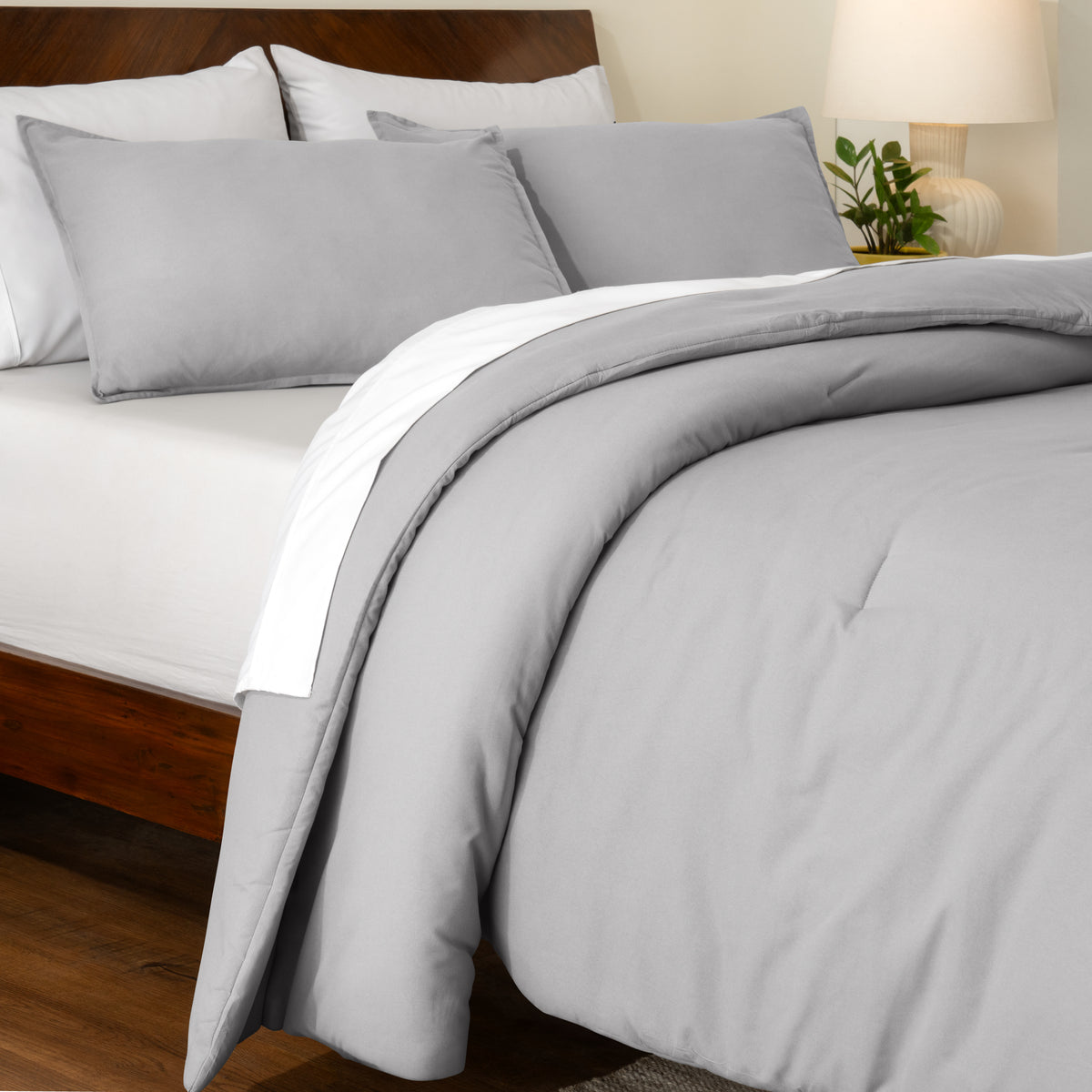 Track stitch comforter on a bed with white pillows and a wooden headboard.