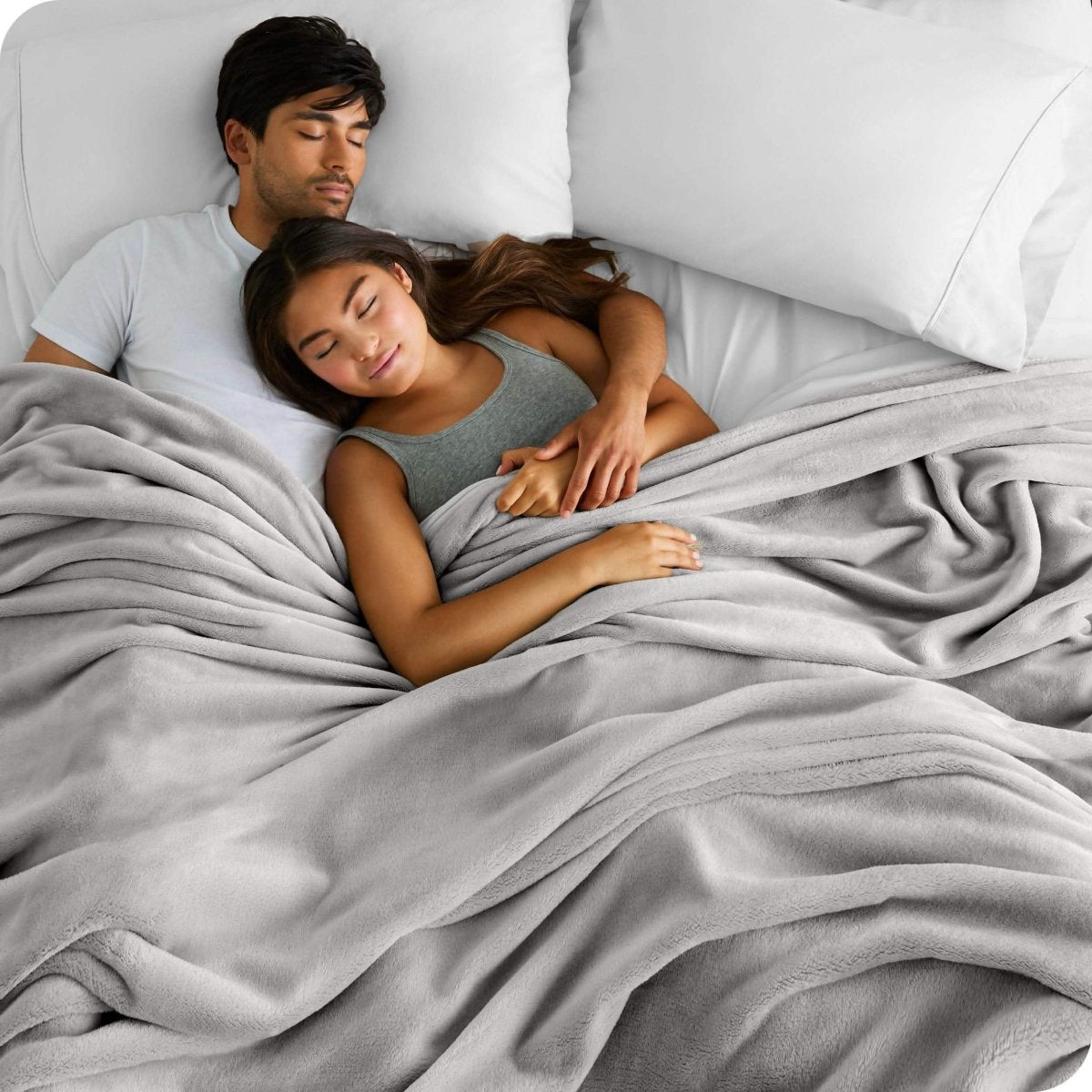 A couple sleeping with covered with a giant microplush blanket