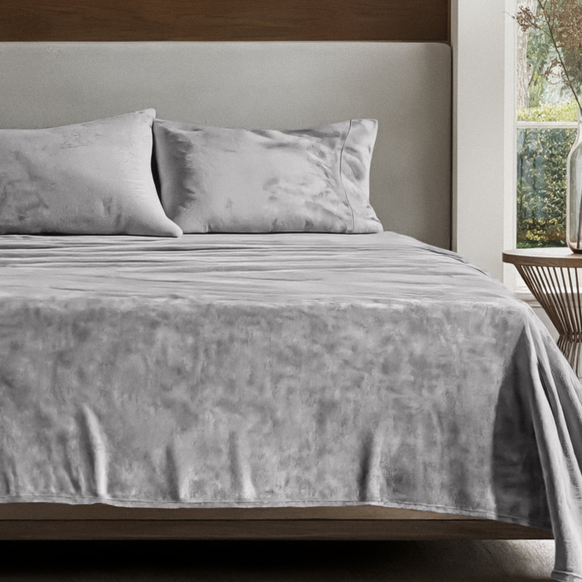Microplush sheet set on a bed in a bedroom setting with a nightstand and lamp.