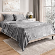 Neatly made bed in a well-lit bedroom.