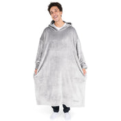 An adult is standing while wearing a long microplush wearable blanket