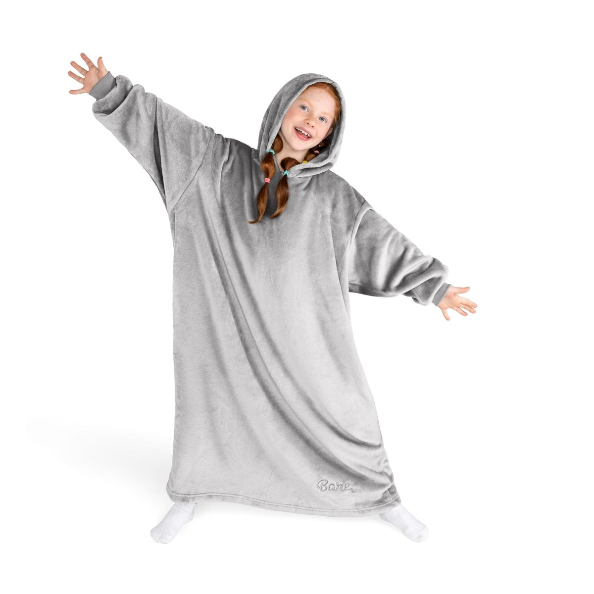 A girl has a hooded blanket on that is long enough to cover her legs