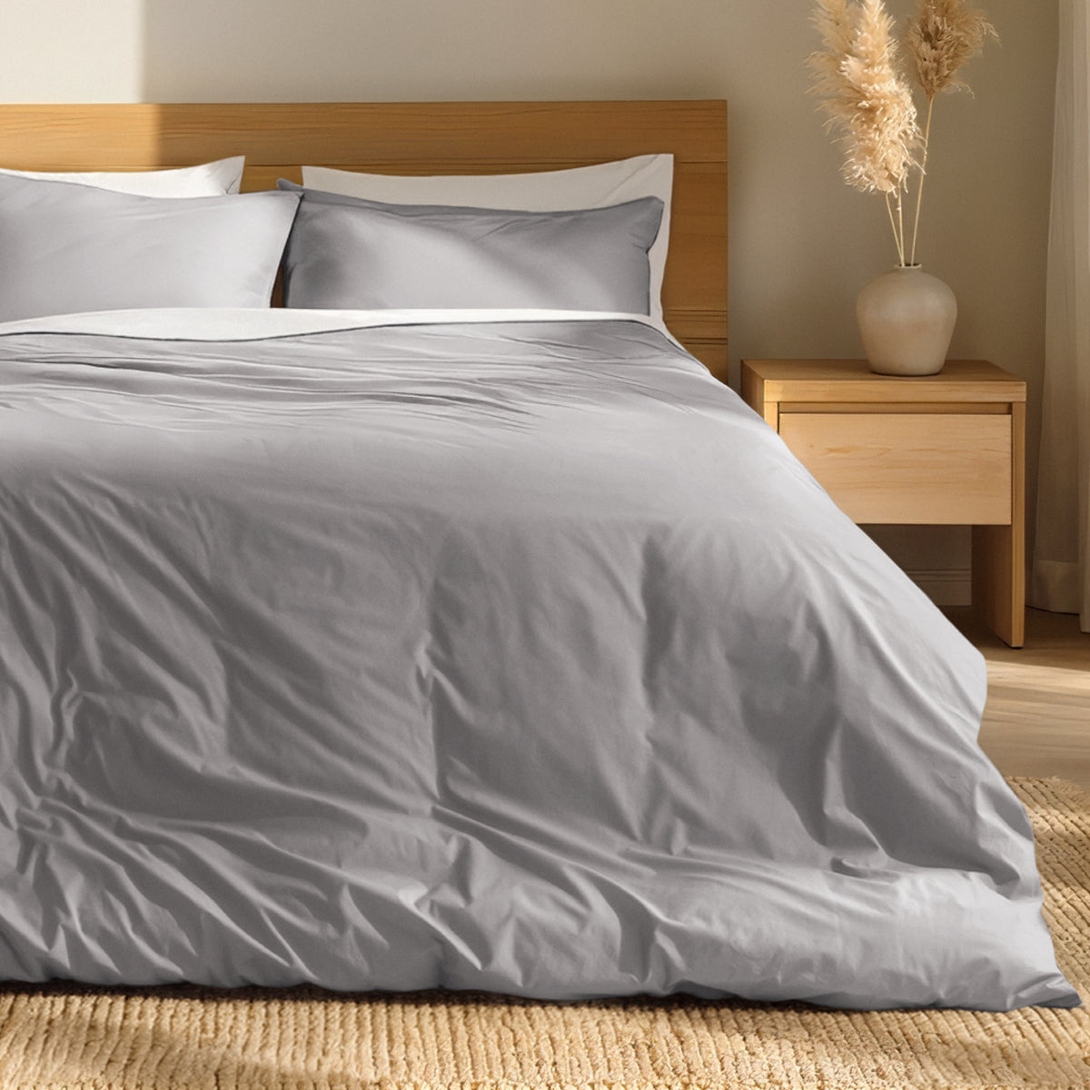 Percale bedding set on a bed with a wooden headboard and nightstand in a bedroom setting.