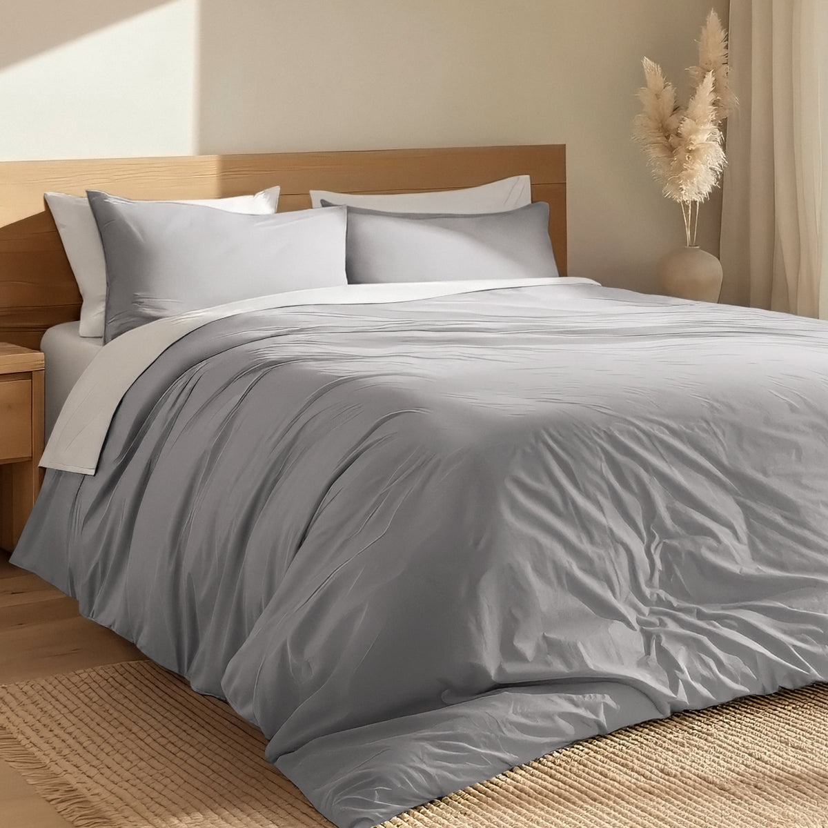 Bed with percale duvet cover set and wooden headboard in a room with a vase and decorative items.