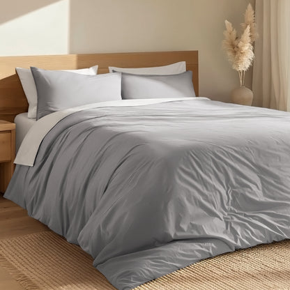 Bed with percale duvet cover set and wooden headboard in a room with a vase and decorative items.