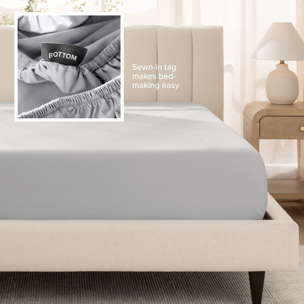 Sateen fitted sheet on a bed with a close-up of a sewn-in tag, set in a bedroom.