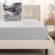 Sateen fitted sheet on a bed with a close-up of a sewn-in tag, set in a bedroom.
