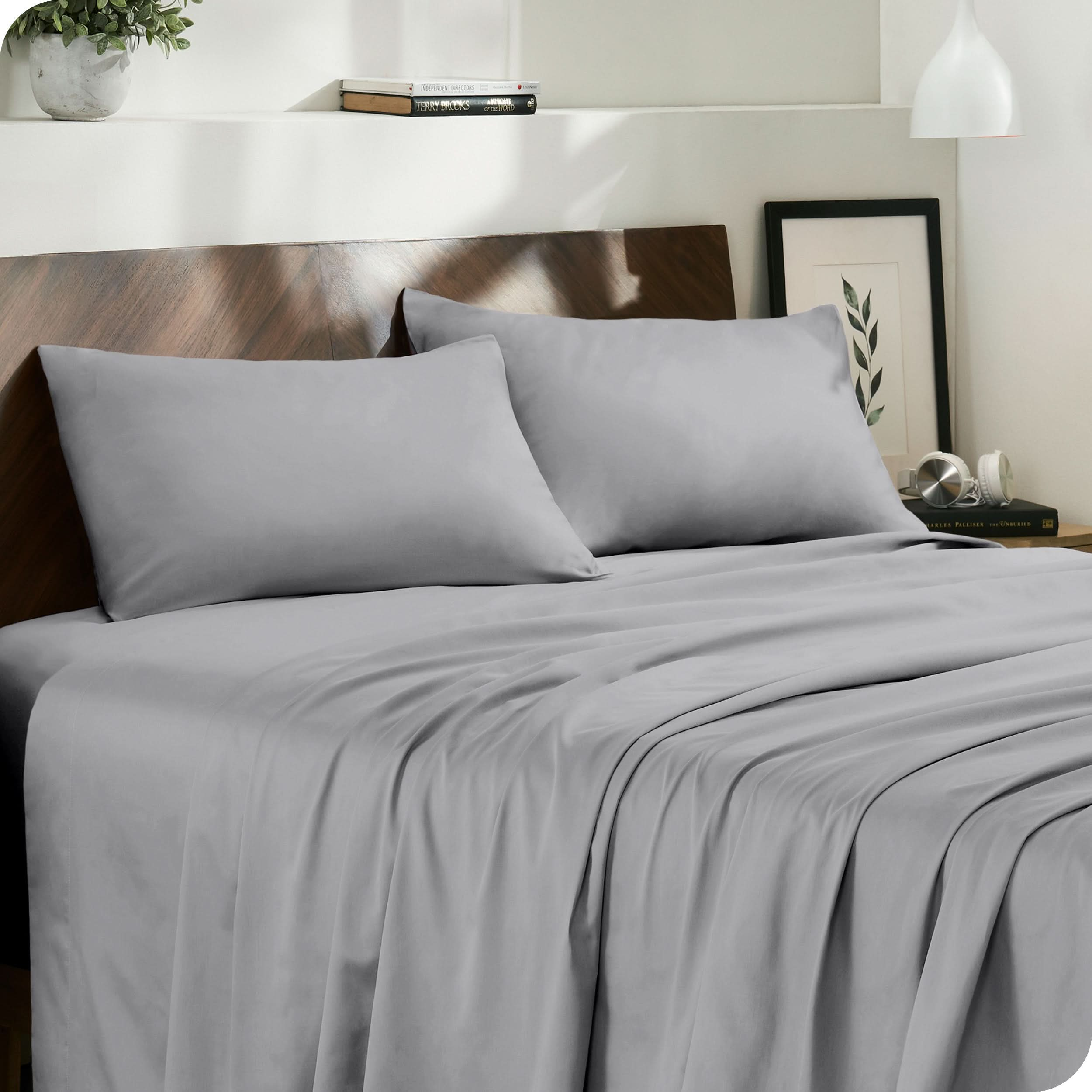 Diagonal view of modern bedroom with sateen sheets and pillowcases on the bed