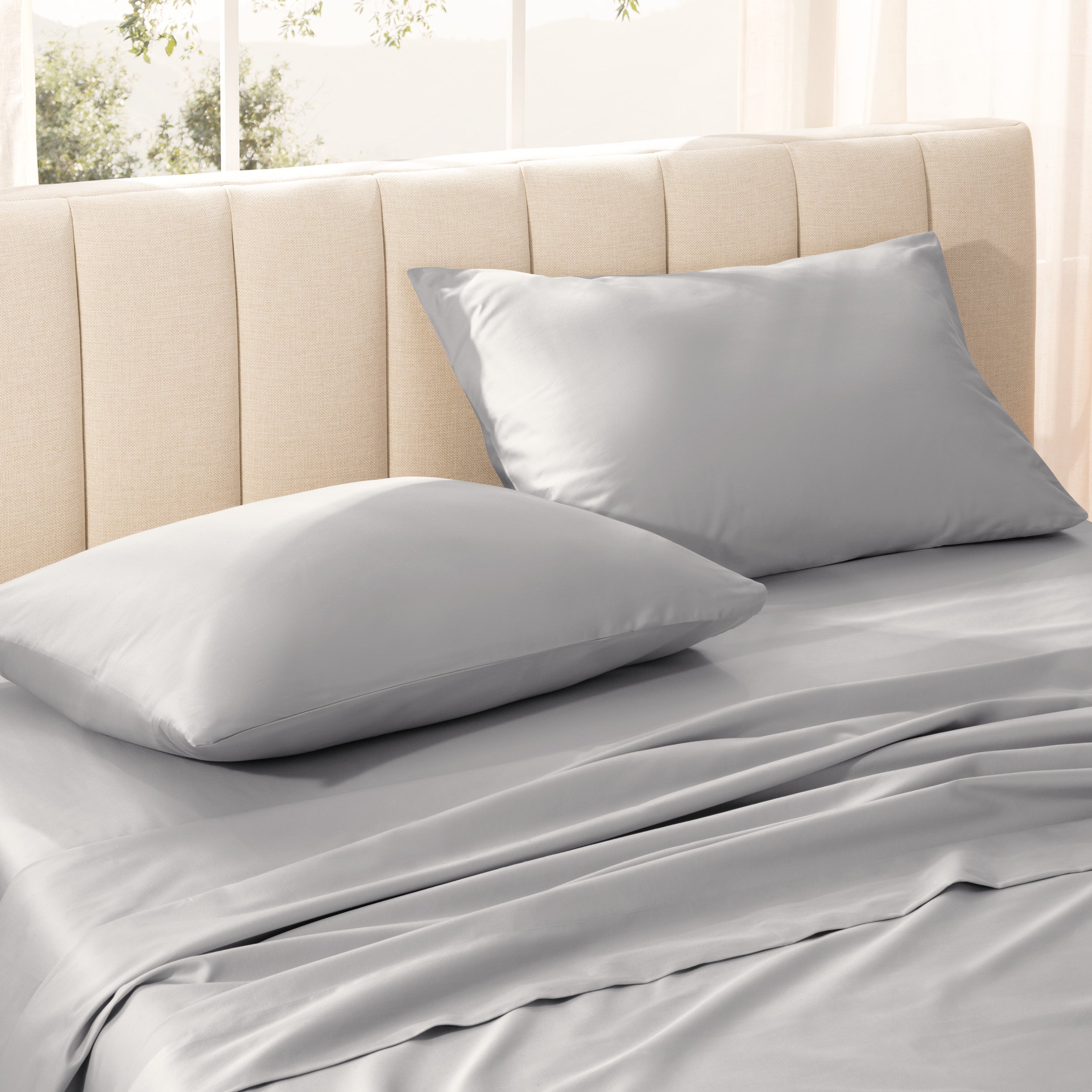 Sateen bedding set on a bed with a beige headboard.