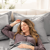 Woman sleeping peacefully in a bed made with sateen sheets and pillowcases.
