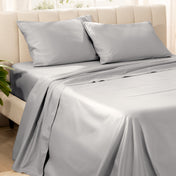 Bedding set on a bed with pillows in a bright room.