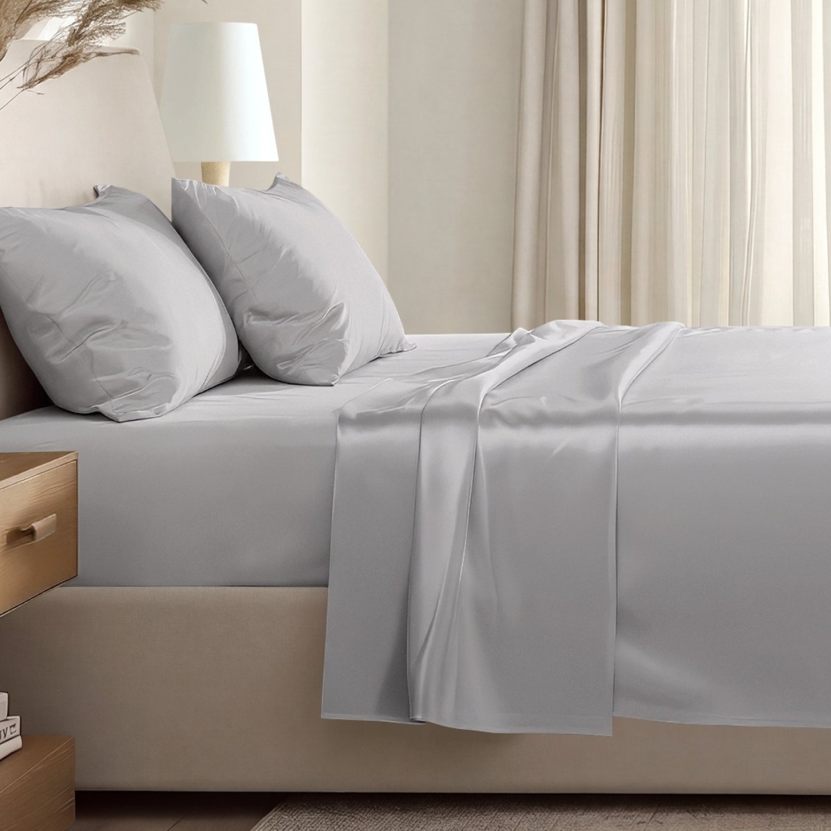 Sateen sheet set on a bed in a softly lit bedroom.