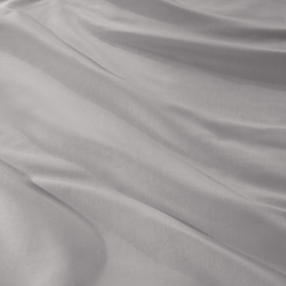A close-up of draped sateen fabric with soft folds and a smooth texture.