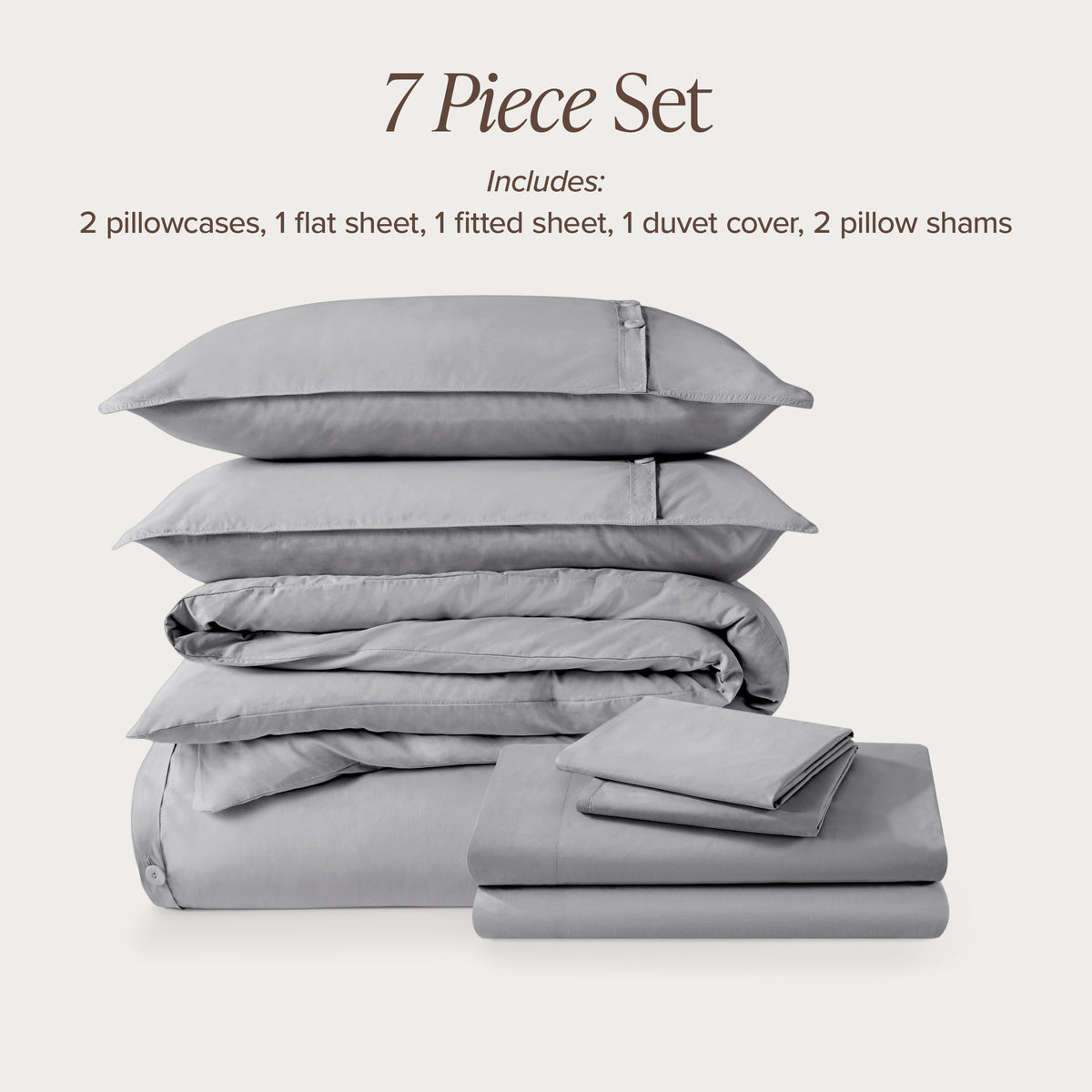7-piece percale bedding set with pillowcases, flat sheet, fitted sheet, duvet cover, and pillow shams on a light background.