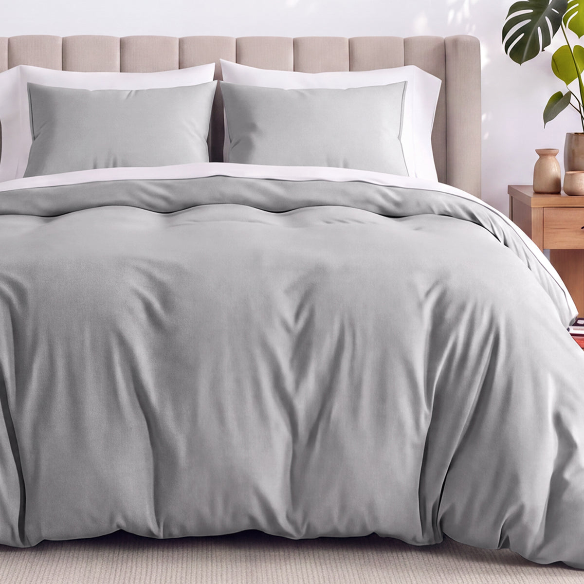 Neatly made bed with organic jersey bedding and pillow shams in a bedroom setting.