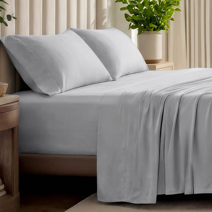 Organic jersey bed sheets and pillows on a bed with a wicker headboard.