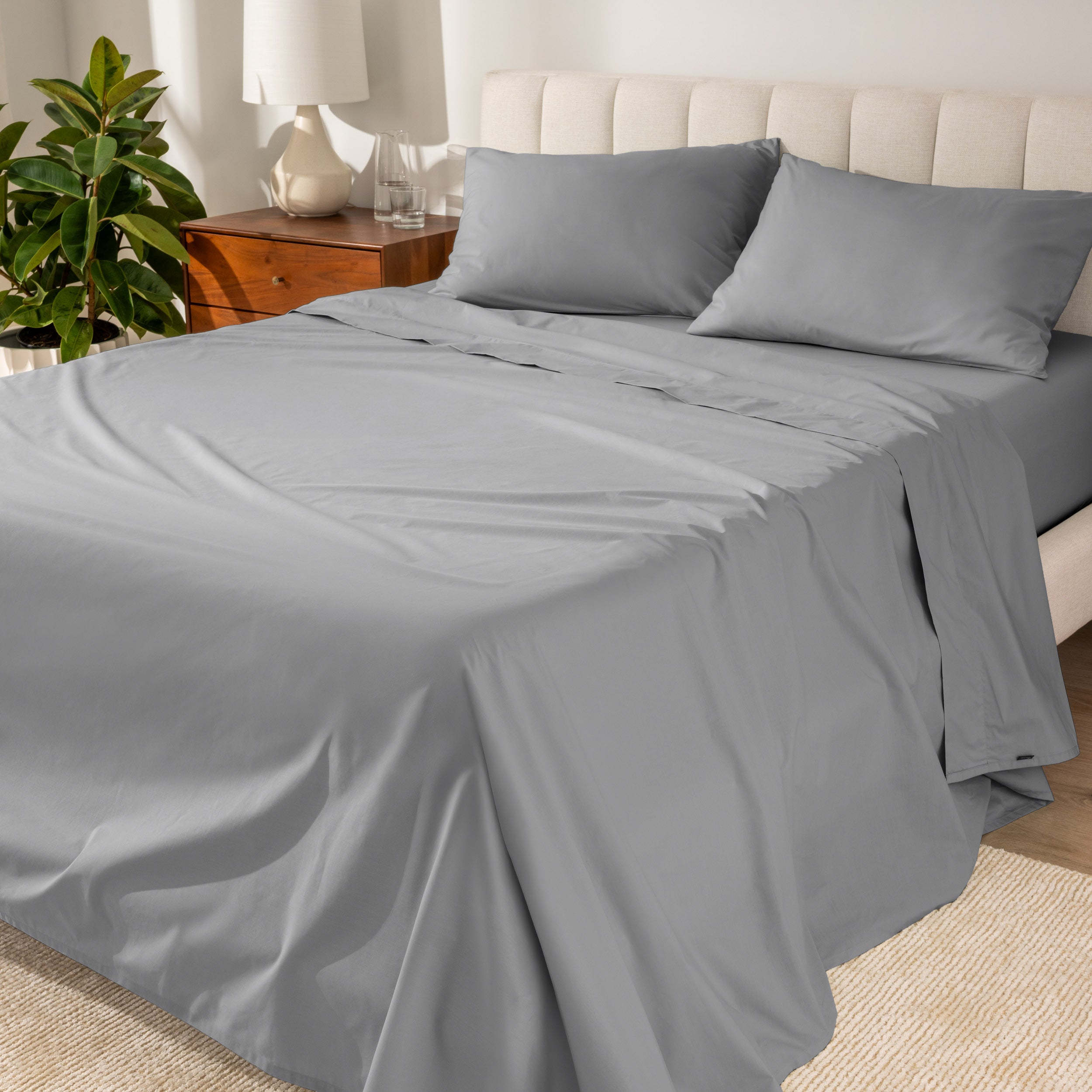 Percale sheets on a bed with a cream colored frame and headboard