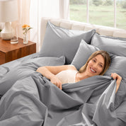 Woman lying in bed with percale bedding in a bright bedroom