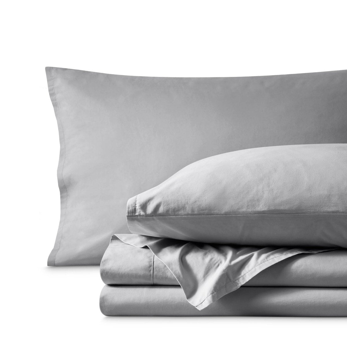 Percale bedding set including pillowcases and folded sheets arranged on a clean white background
