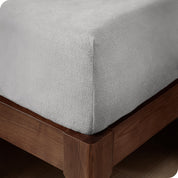 A corner of a modern bed with a polar fleece fitted sheet on.