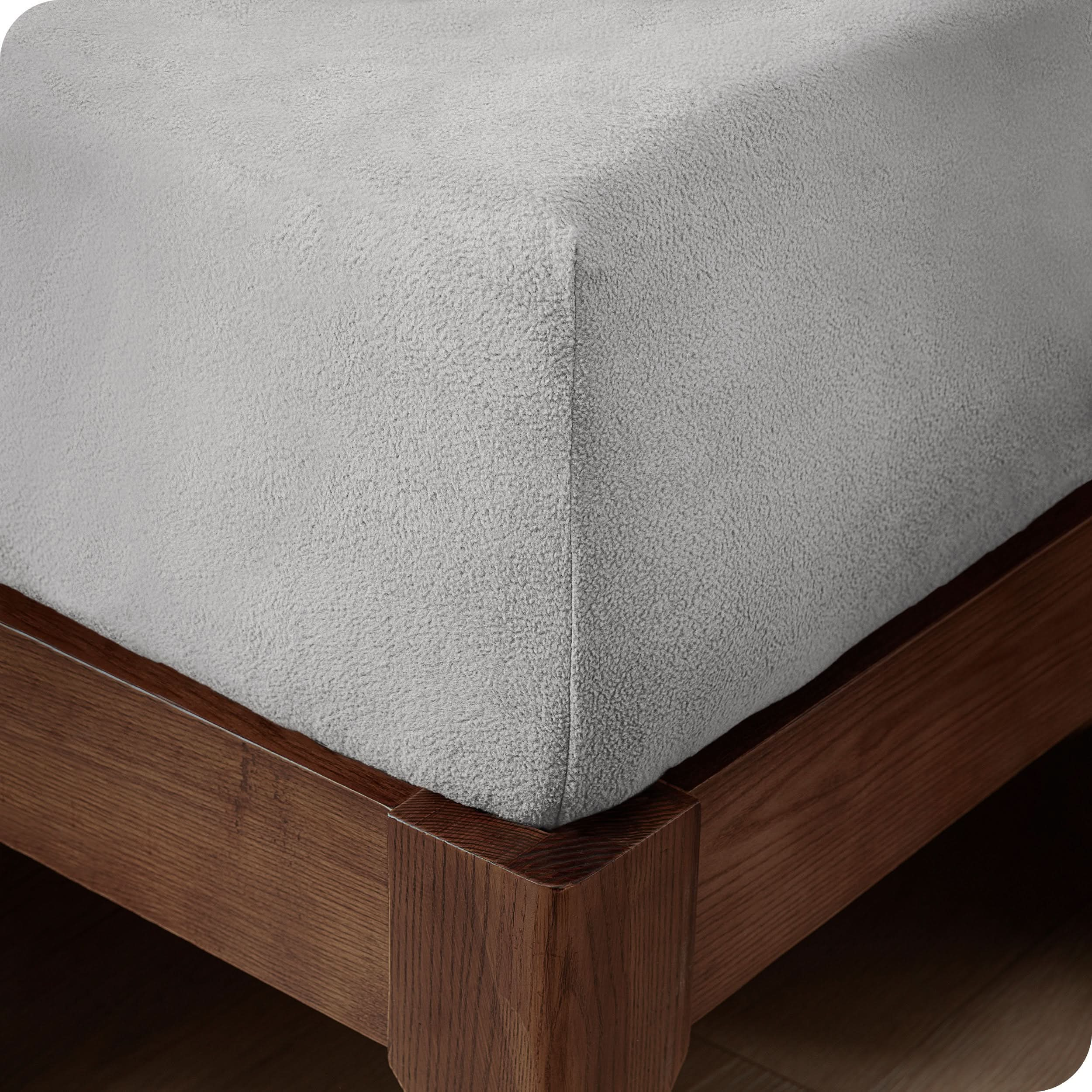 A corner of a modern bed with a polar fleece fitted sheet on.