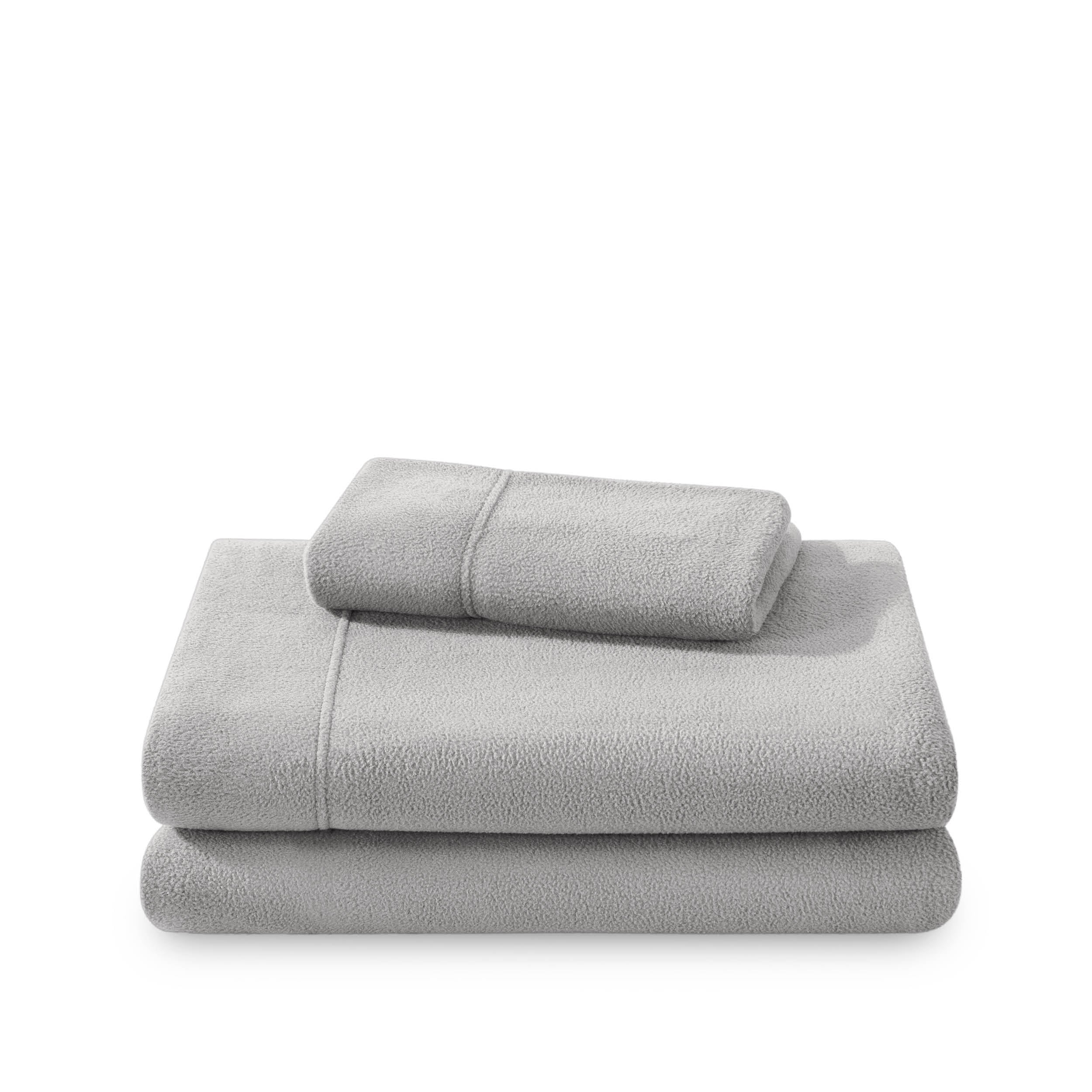 Polar fleece sheets and pillowcases folded and stacked on a white background