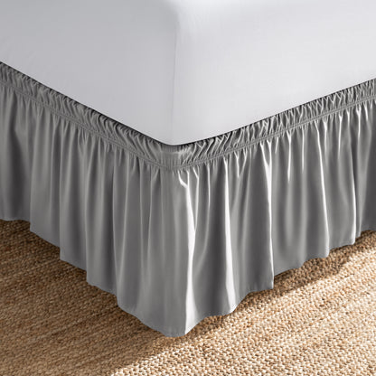 Bed with white fitted sheet and an adjustable bed skirt.