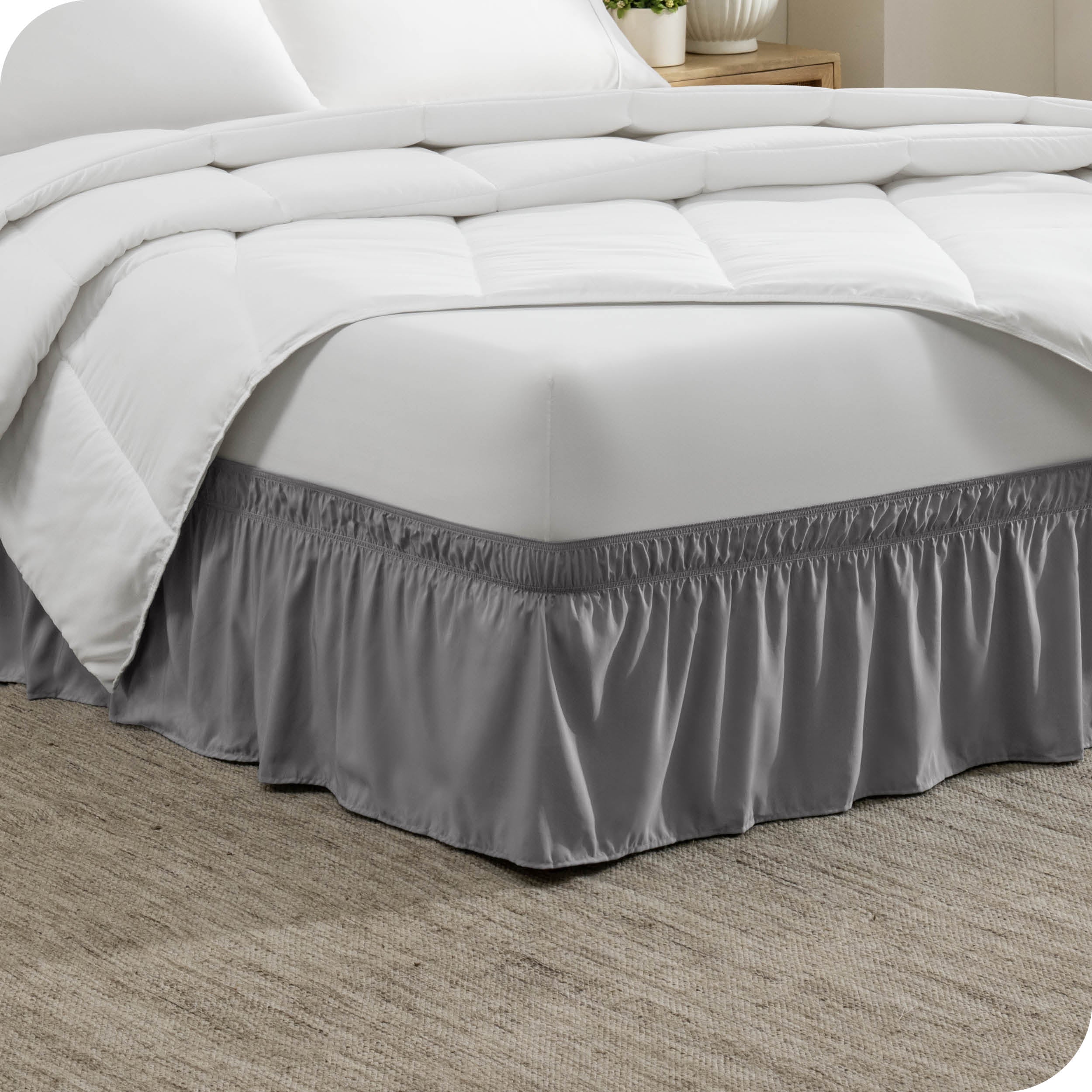 Corner of a bed with a polyester wrap around bed skirt on it