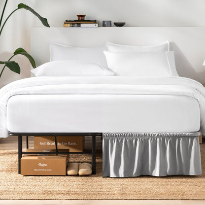 Bed with white bedding and a plant near the bed.