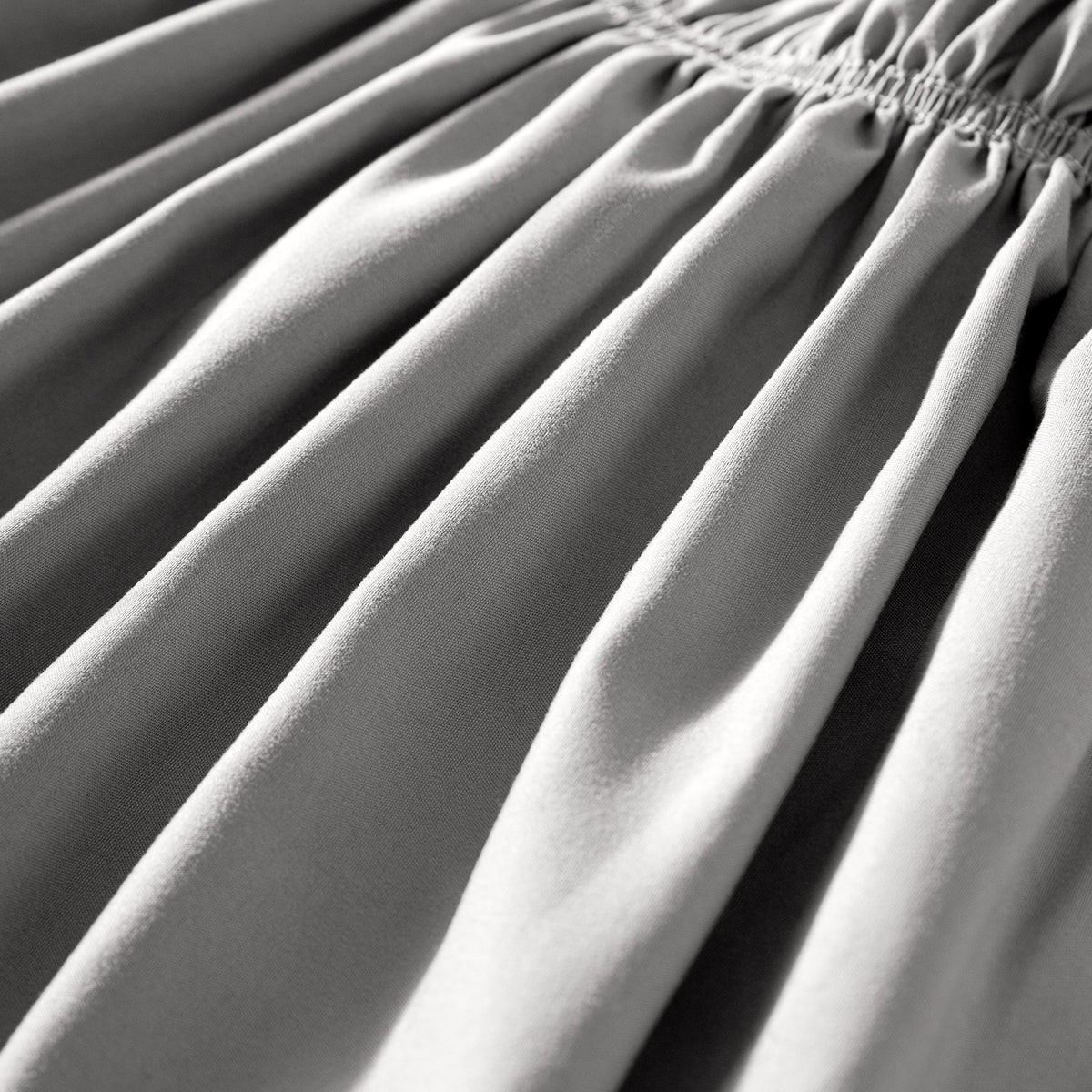 Close-up of polyester bed skirt fabric with a focus on texture and folds.